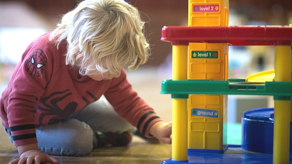 Мальчик играет с игрушками в игровой группе для детей дошкольного возраста в 2015 году.
