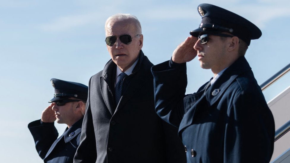 El presidente de EE.UU., Joe Biden, entre dos militares formados