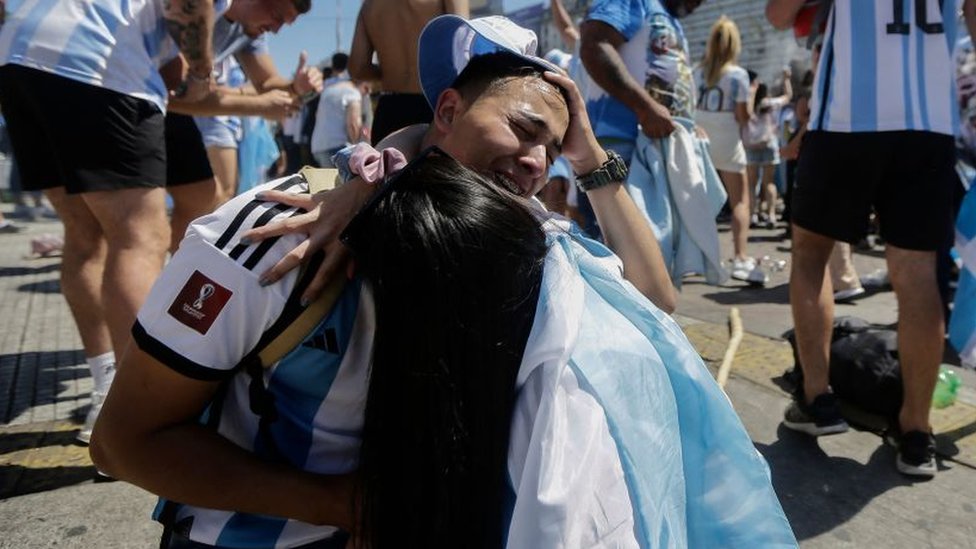 Dos personas se abrazan entre lágrimas en la zona del Obelisco en Buenos Aires, Argentina.