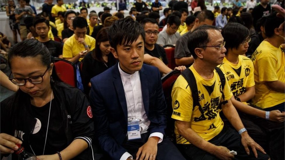 Чэн Чжун-тай из Civic Passion (в центре слева) сидит со сторонниками после своей победы на выборах в Законодательный совет на центральном участке подсчета голосов в Гонконге 5 сентября 2016 года.