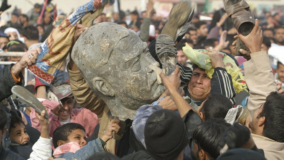 Иракцы с частью статуи бывшего диктатора Саддама Хусейна