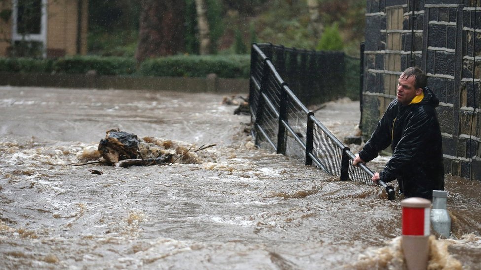 Жители борются с наводнением, когда река Колдер выходит из берегов в городе Митхолмройд в Западном Йоркшире 26 декабря 2015 года