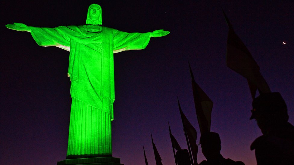 Soldiers in ceremonial costume line up in front of Christ the Redeemer statue in Rio de Janeiro