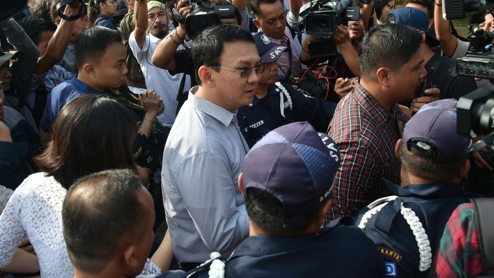 Incumbent Jakarta governor Basuki Tjahaja Purnama (C) is surrounded by journalists after voting at a polling station during the final-round of the Jakarta governor election in Jakarta on April 19, 2017