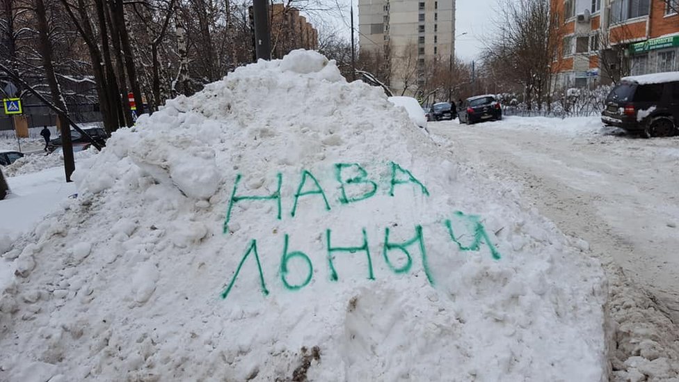 Имя лидера российской оппозиции Алексея Навального нарисовано распылителем на сугробе в Москве.