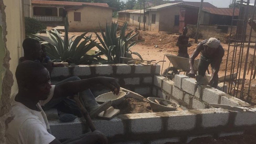 Строители строят стену в Гане