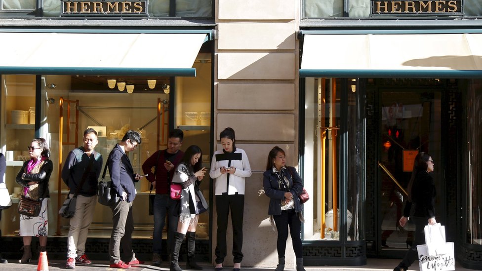Клиенты выстраиваются в очередь в ожидании открытия главного магазина французской роскошной группы Hermes в Париже, Франция, 23 сентября 2015 г. фото из файла