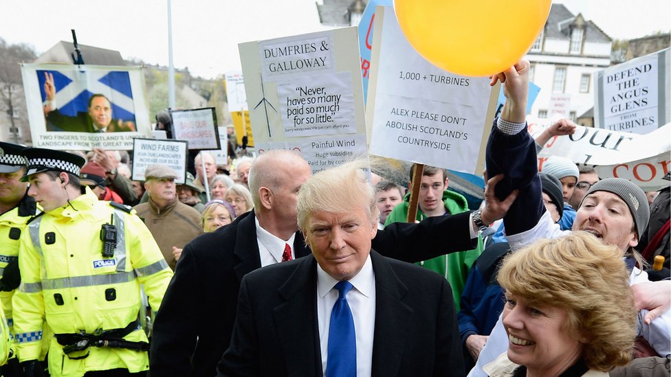 Протестующий трет волосы Дональда Трампа воздушным шаром, заставляя их встать дыбом
