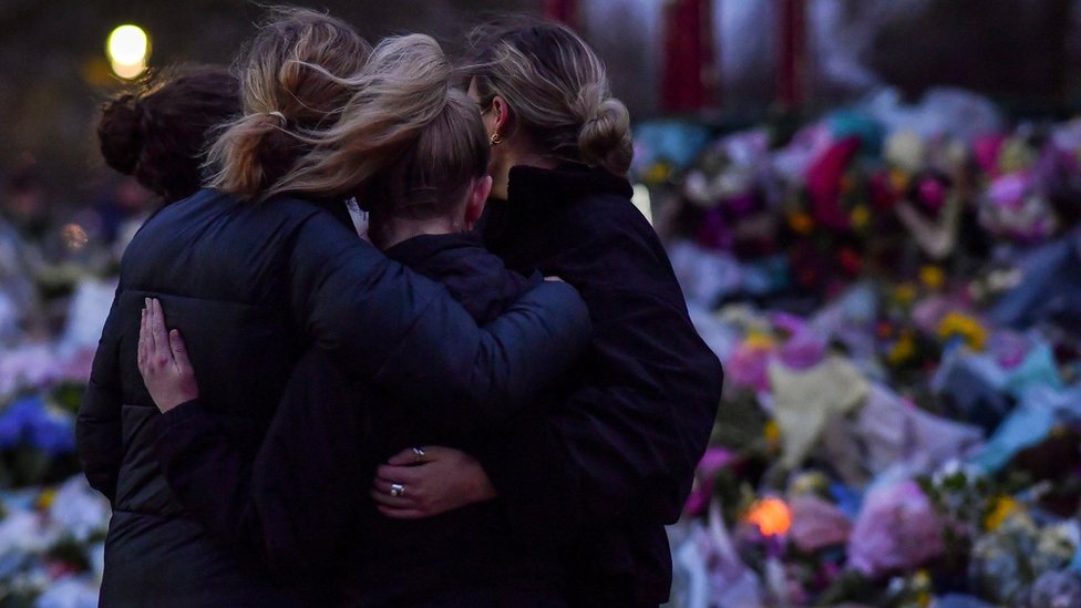 People embrace at the memorial site on London's Clapham Common following the kidnap and murder of Sarah Everard, in March this year