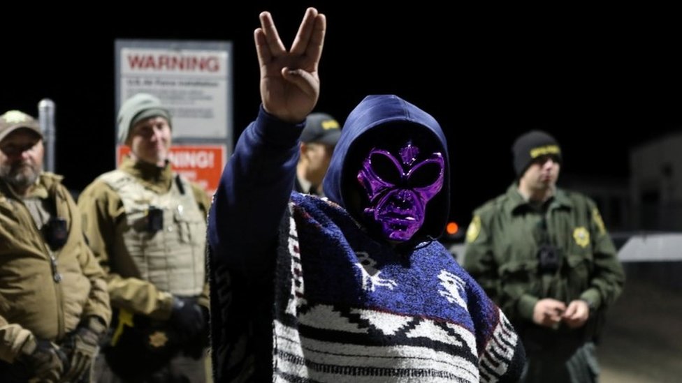 An attendee wears an alien mask at the gate of Area 51 as an influx of tourists responding to a call to "storm" Area 51