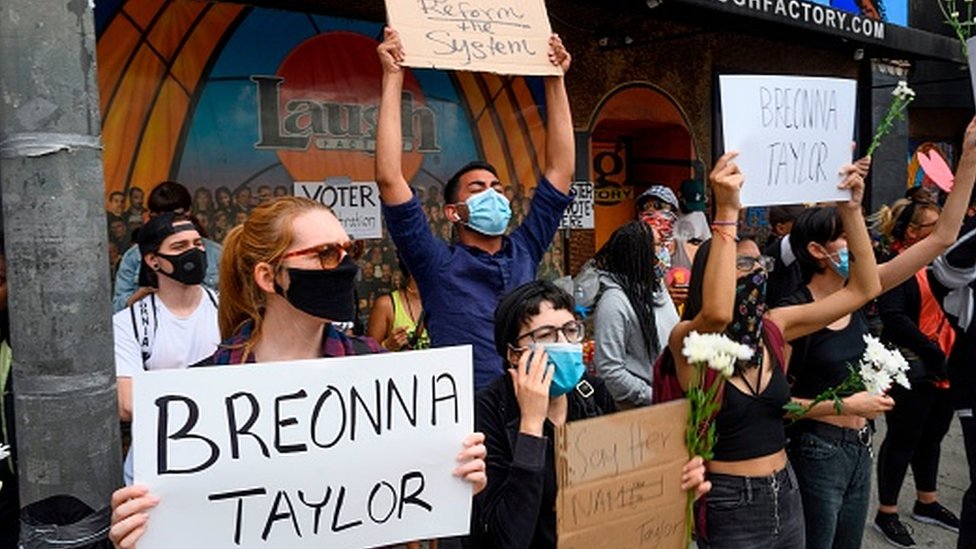 Протестующие Black Lives Matter держат плакаты в память о Бреонне Тейлор в день ее 27-летия в Голливуде, Калифорния