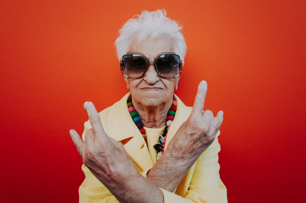 Una mujer mayor con pose rockera