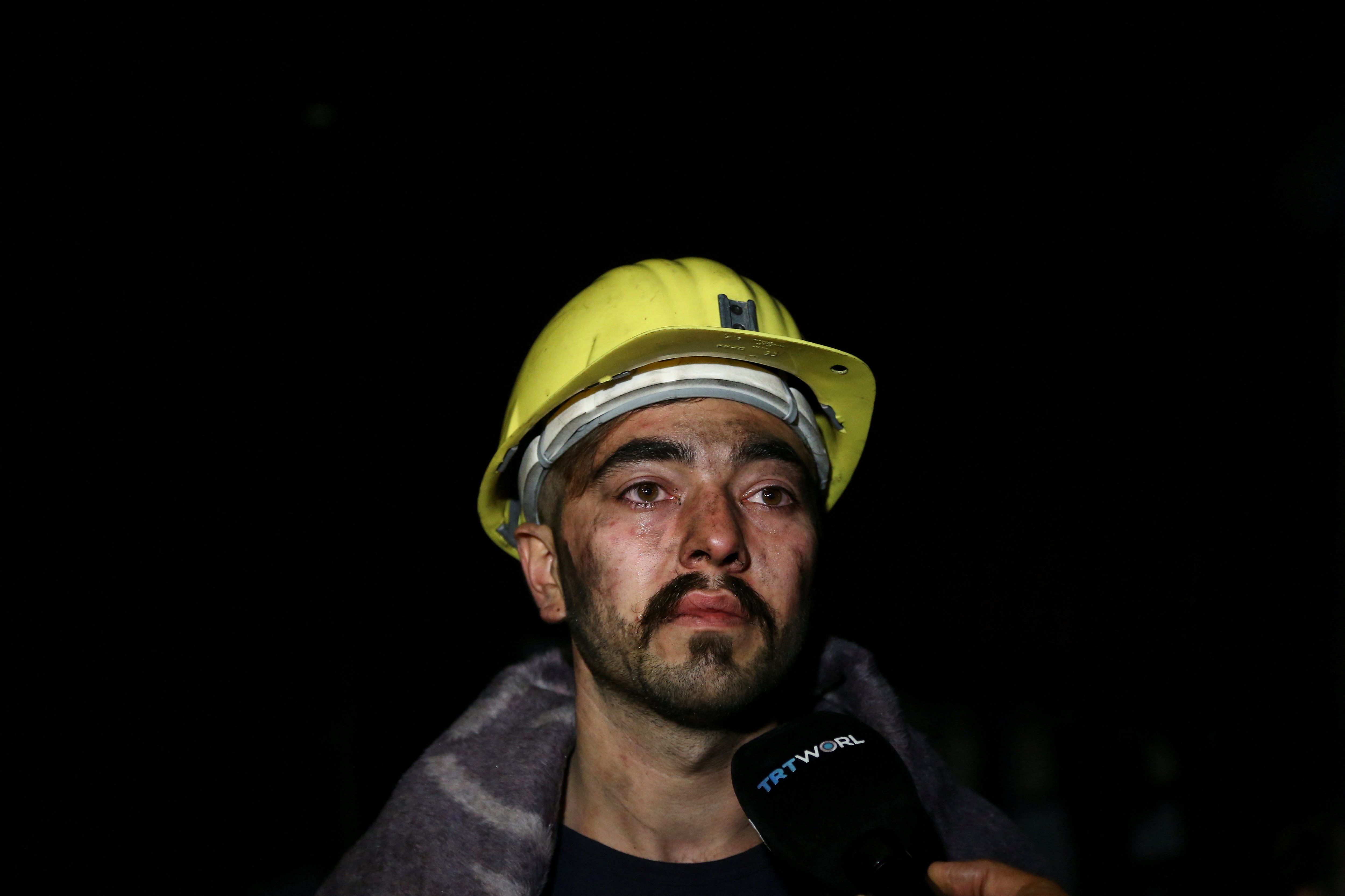 عامل في منجم الفحم يتحدث إلى وسائل الإعلام أمام الموقع ويبدو التأثر على ملامح وجهه