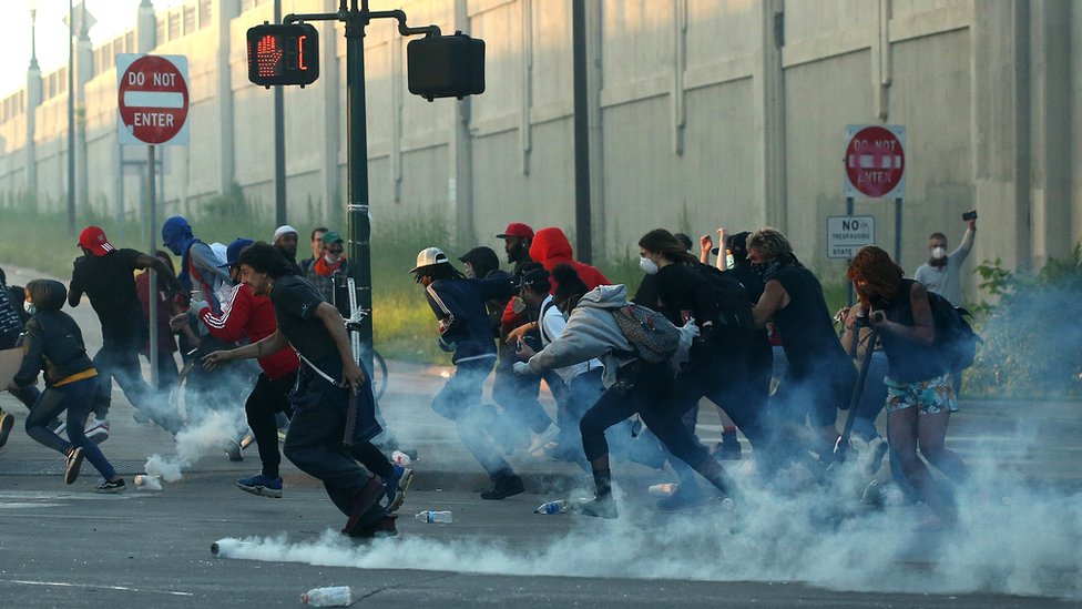 People run as tear gas canisters land near them during a protest sparked by the death of George Floyd while he was in police custody, in Minneapolis, Minnesota, 29 May 2020