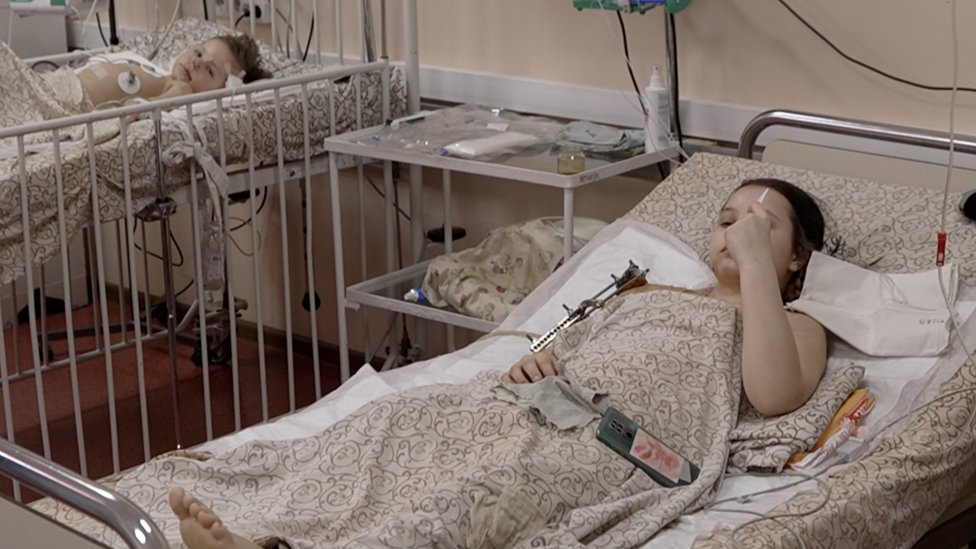 Masha lies in her hospital bed