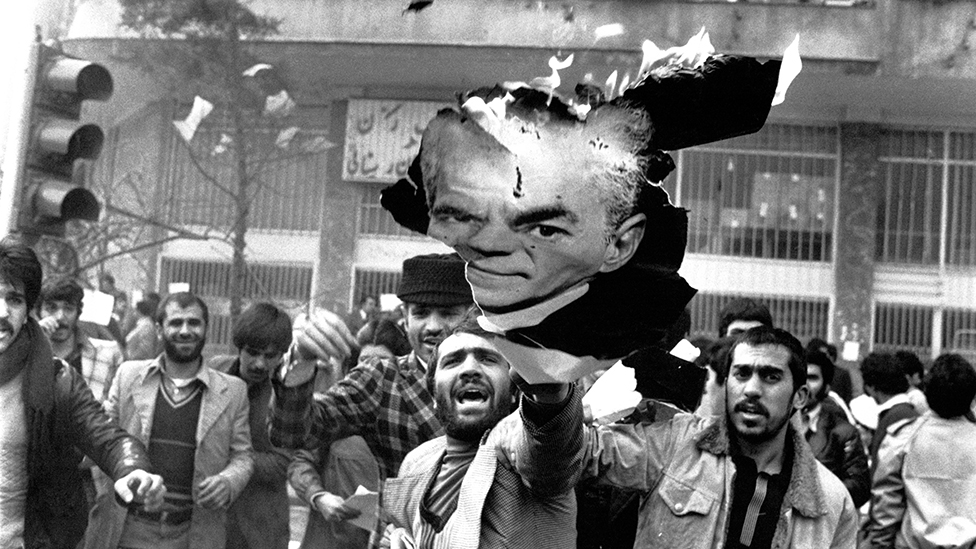 Manifestantes en Irán queman una imagen del sha en 1978.