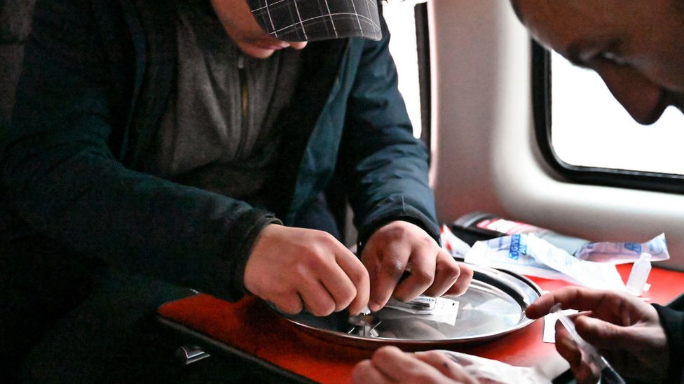 Dos consumidores preparan la cocaína antes de inyectarse, dentro de una camioneta de consumo segura creada por un exadicto en recuperación.