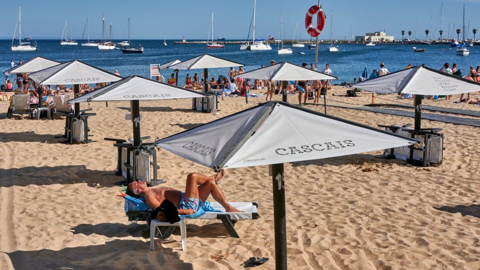 Люди на пляже в Португалии