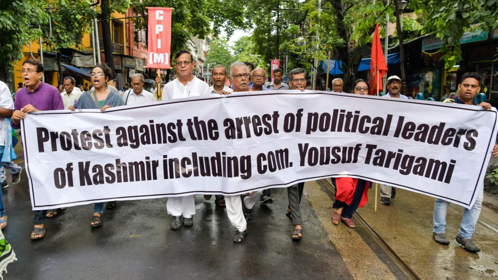 Члены партий Левого фронта маршируют со знаменем во время митинга протеста против отмены статьи 370 в Калькутте