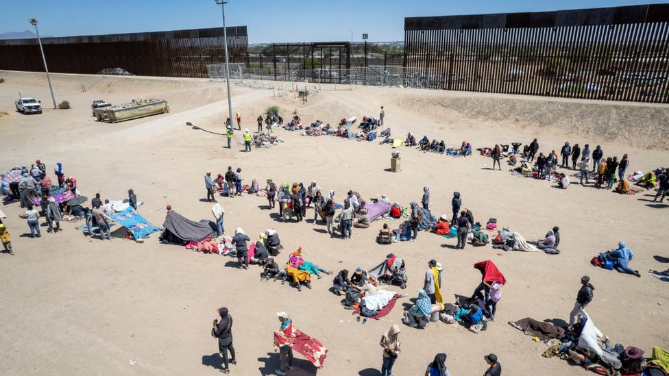 Vista aérea de filas de migrantes detrás del muro que separa Ciudad Juárez de El Paso.