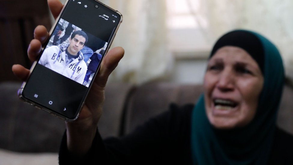 Мать Ияда Халака держит его фотографию на мобильный телефон (30 мая 2020 г.)