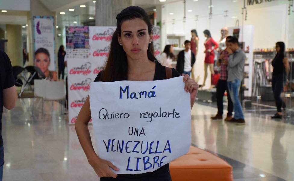 Габриэла Саяго держит знак протеста