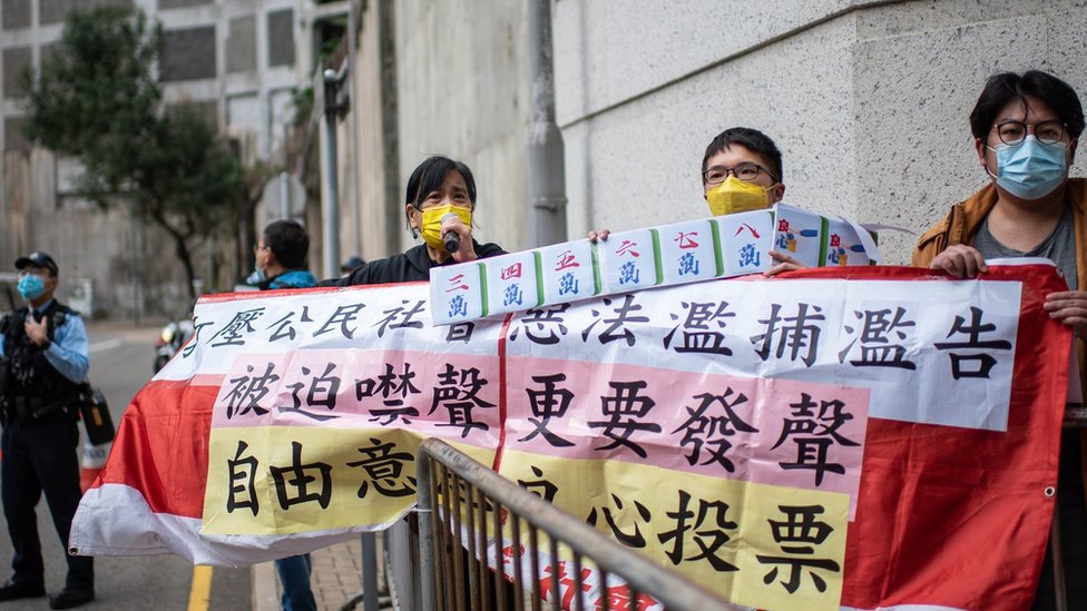 Members of the League of Social Democrats hold a three-person protest outside the polling station where Hong Kong Chief Executive casts her vote in the Legislative Council election on December 19, 2021 in Hong Kong, China.