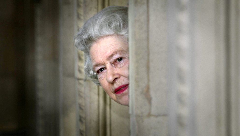 La reina Isabel II espía desde una esquina durante una visita al Royal Albert Hall de Londres, tras el final de un programa de restauración de 8 años.