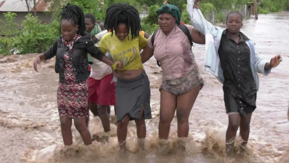 نساء يحاولن السير وسط فيضانات