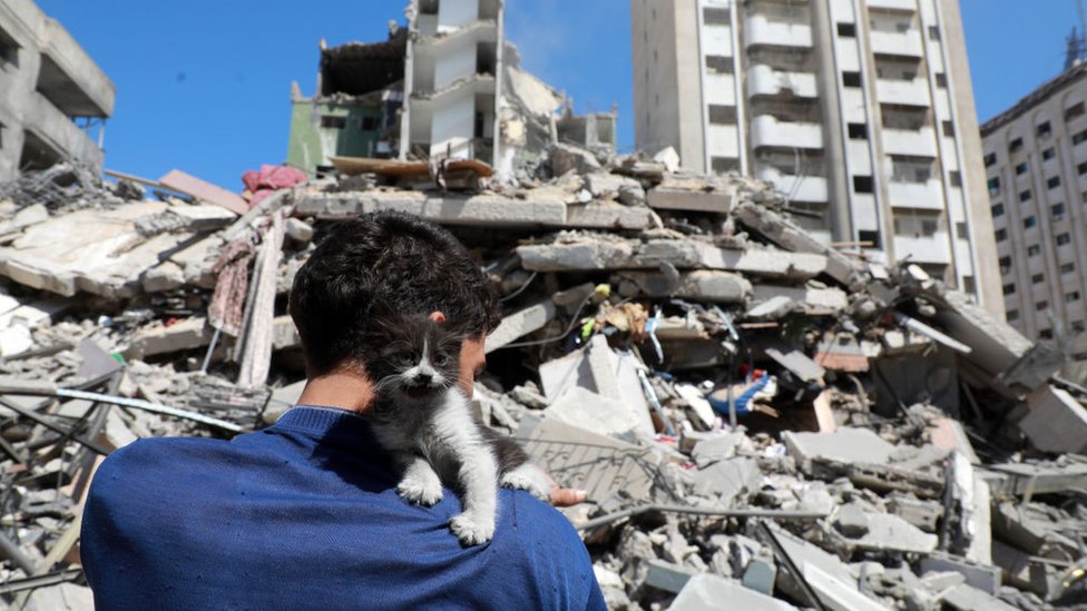 Un hombre mira un edificio totalmente destruido en un bombardeo.
