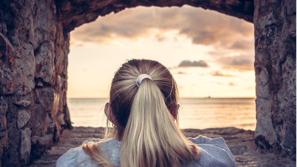 El fenómeno de "desrealización" se produce cuando las personas se ven a sí mismas y al ambiente que las rodea como si no fueran reales, como si estuvieran en un sueño. Mujer mirando al infinito