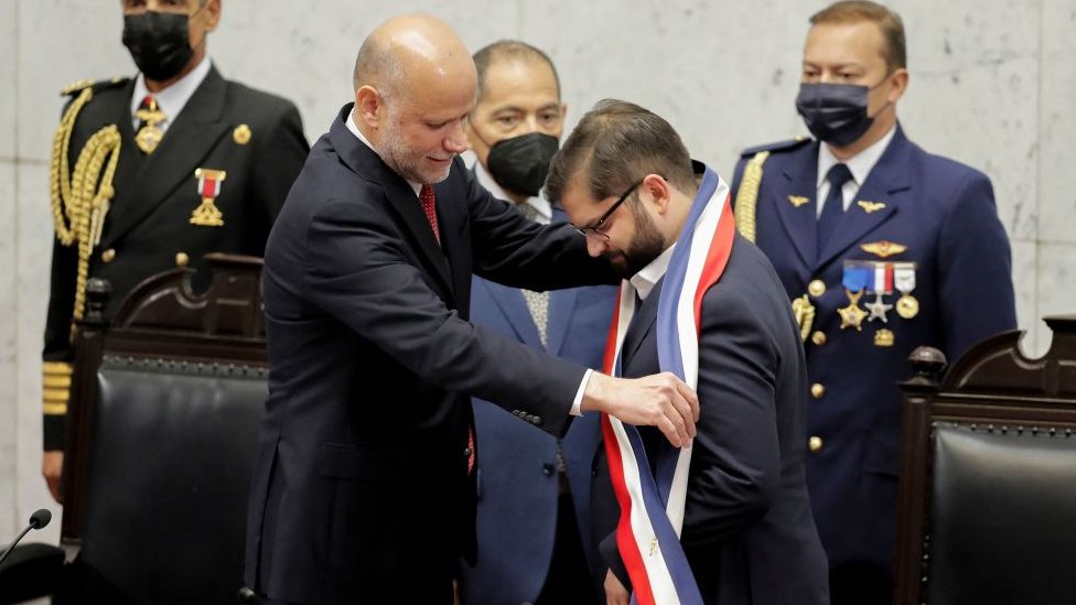 El presidente del Senado de Chile, Álvaro Elizalde, le entrega la banda presidencial al nuevo mandatario, Gabriel Boric.