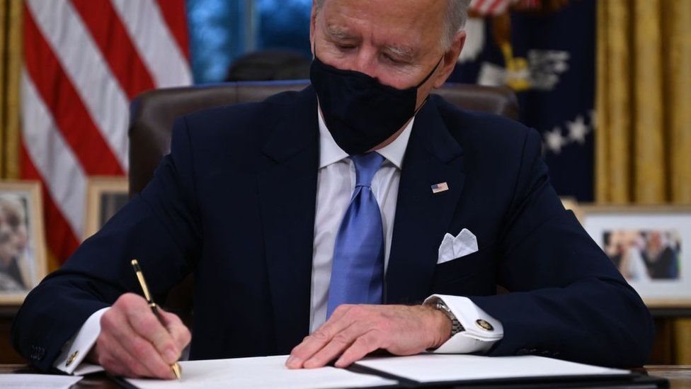 Biden firmando una orden ejecutiva