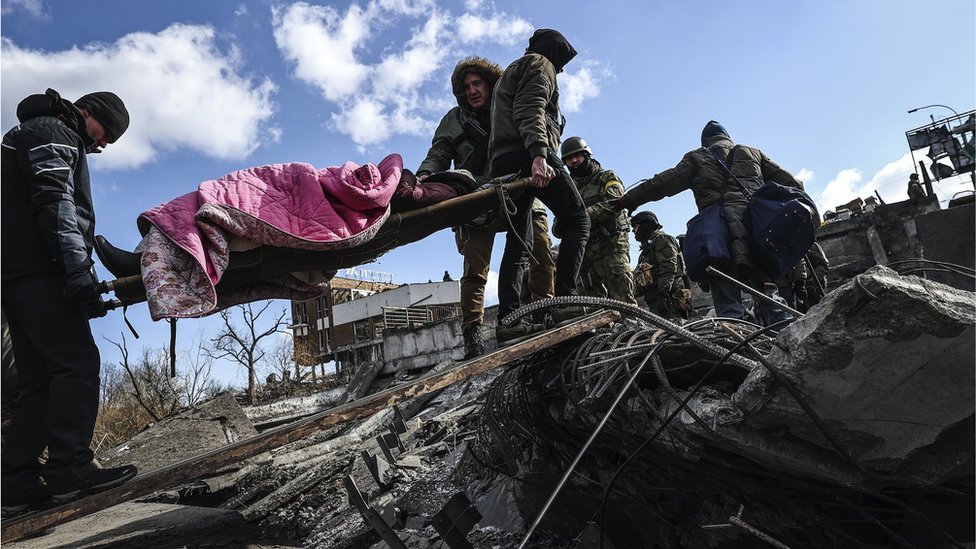 Moradores e militares ajudam uma idosa a fugir da cidade da linha de frente de Irpin, região de Kiev (Kiev), Ucrânia, 10 de março de 2022