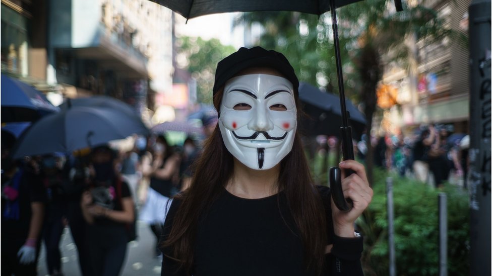 На этом снимке, сделанном 1 октября 2019 года, протестующий носит маску Гая Фокса, закрывающую ее лицо, популяризированную фильмом комиксов V For Vendetta в Гонконге
