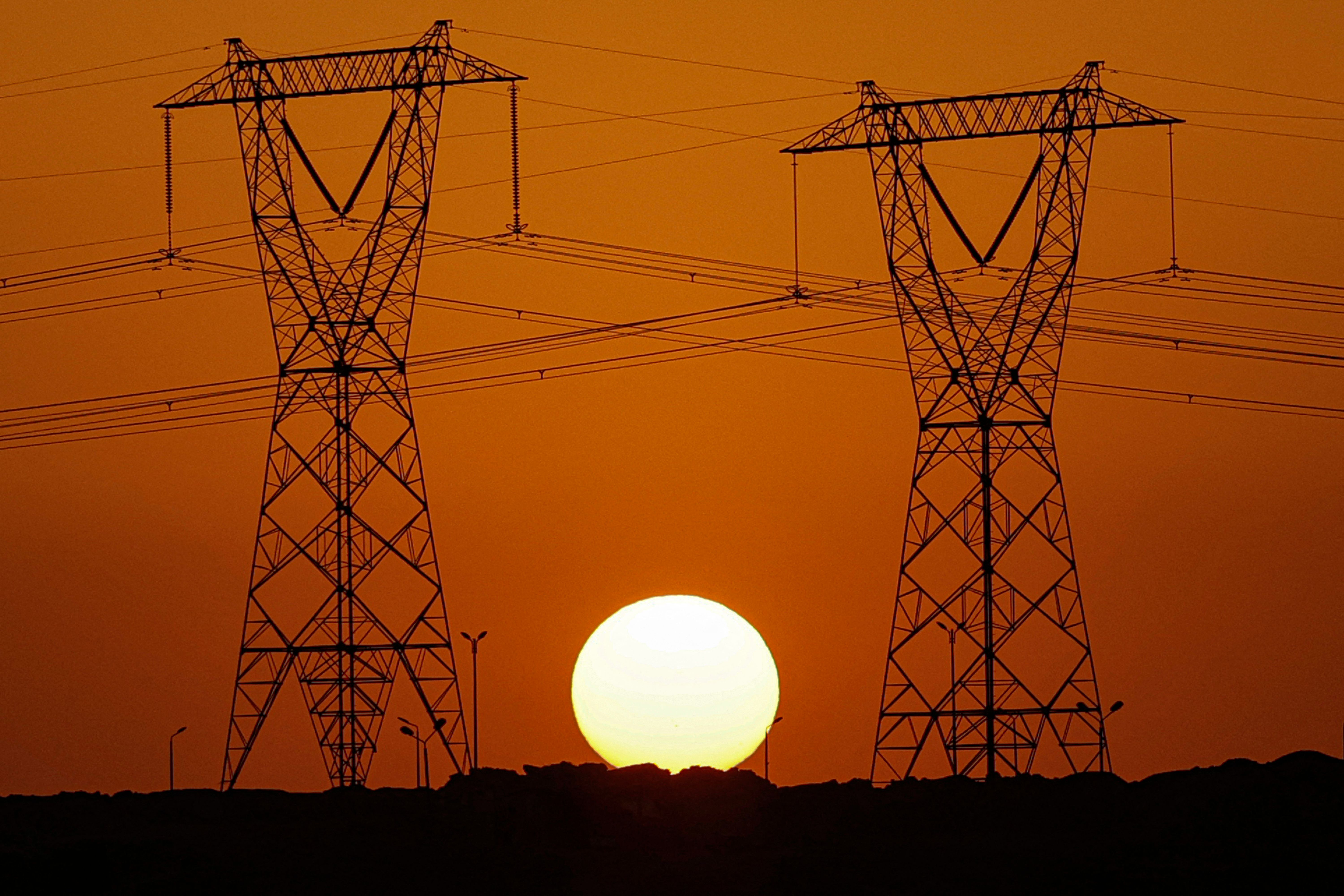 أبراج كهرباء في مصر وخلفها غروب الشمس