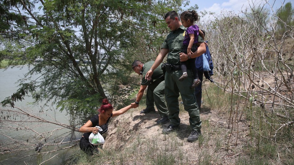 Agentes fronterizos de EE.UU. ayudando a una familia de indocumentados que acaba de cruzar el Rio Grande por Texas. Migrantes indocumentados cruzando el Río Grande