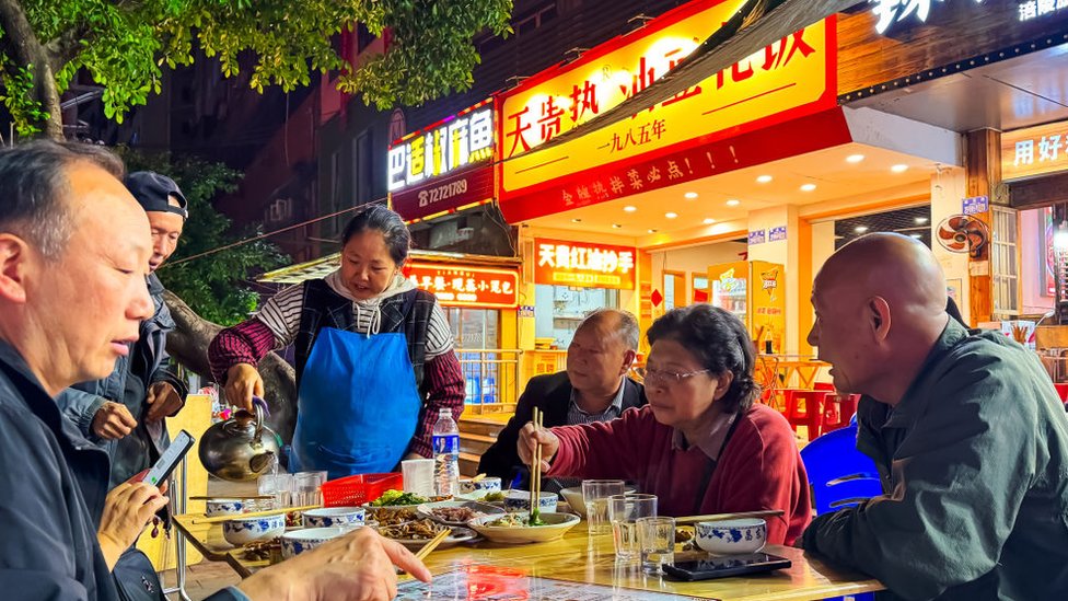 一些中老年市民在戶外吃飯。