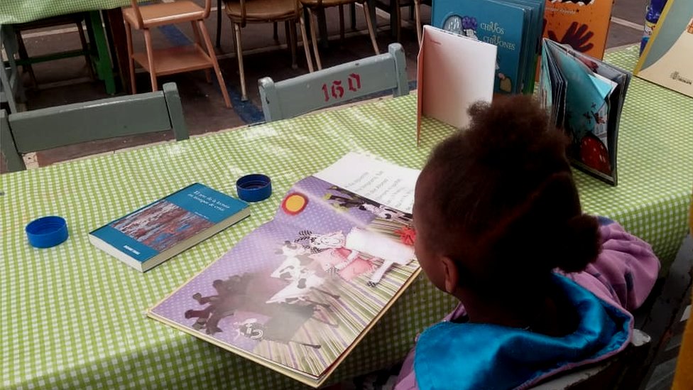 Ребенок читает в центре для мигрантов Cafemin в Мехико
