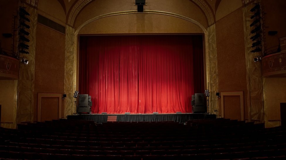 Вид на красный занавес на сцене пустого театра