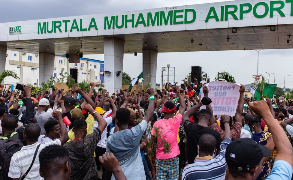 Crowds gather on a main road