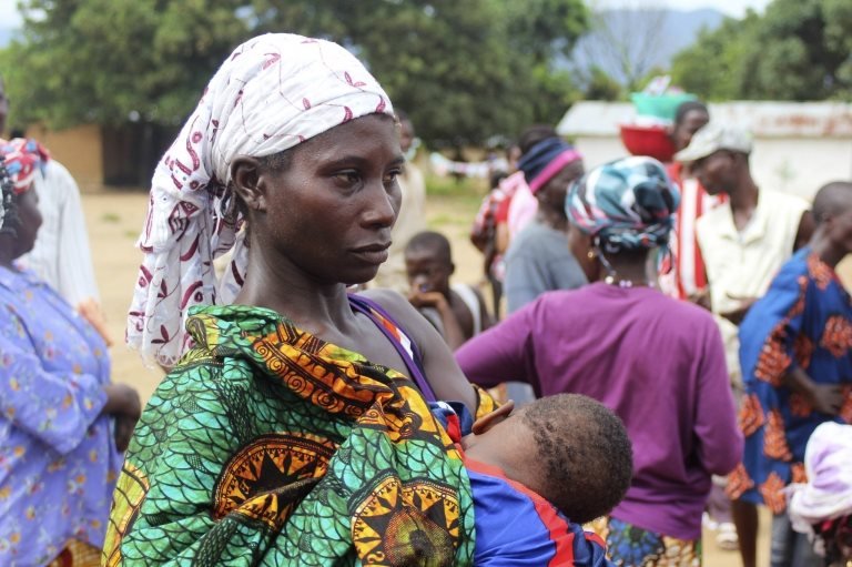 Sierra Leone'de kucağında çocuğuyla yemek kuyruğunda bekleyen bir kadın