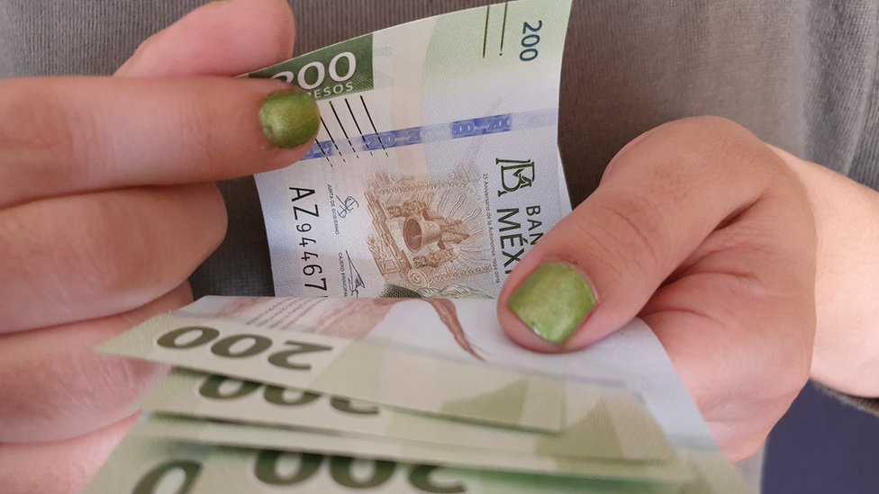 Una mujer cuenta billetes mexicanos