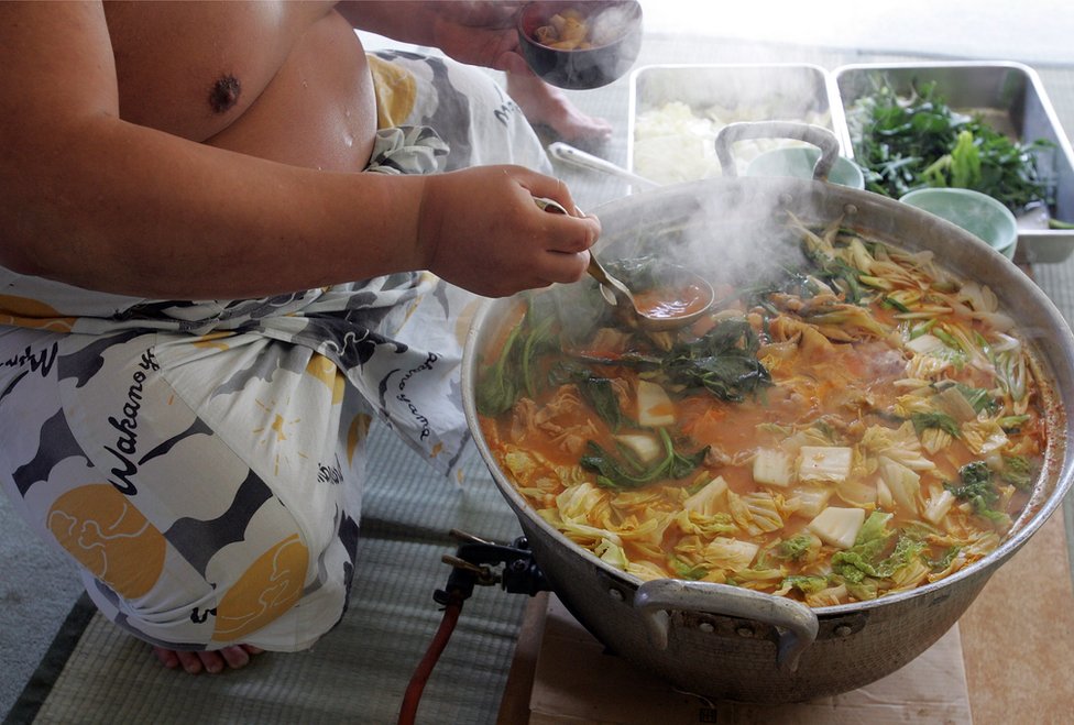 Un luchador de sumo sirve chanko-nabe, un guiso rico en proteínas. (Foto: Junko Kimura/Getty Images) Un luchador de sumo cocina un guiso. (Foto: Junko Kimura/Getty Images)
