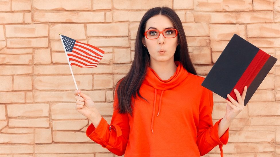 A young woman whistling, holding an American flag