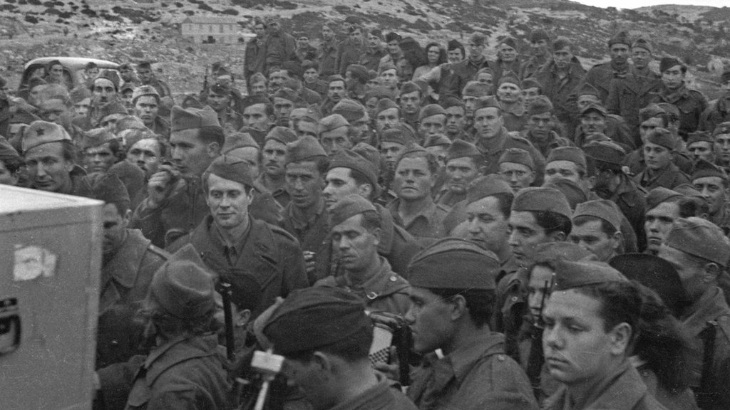 In March 1944 Denis Johnston, BBC War Correpondent visited Yugoslavian Partisans on an island off the coast of Yugoslavia. Recordings were made of a march past nad of songs and speeches.Partisans listening to playback of their march past recordings. Copyright BBC