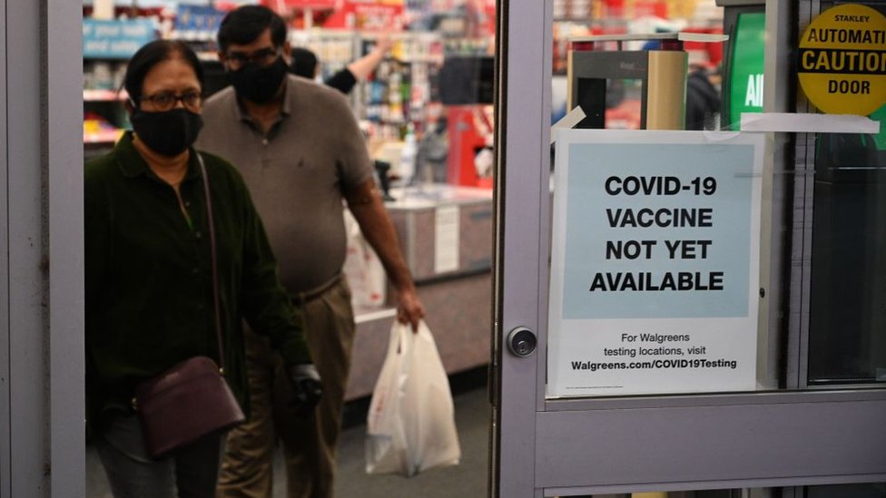 Placa em porta de farmácia diz que 'Vacina para covid-19 ainda não está disponível'