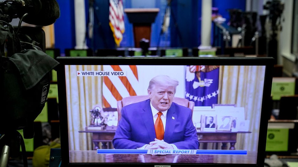 A television monitor in the White House Press Briefing Room displays a recorded address by former President Donald Trump