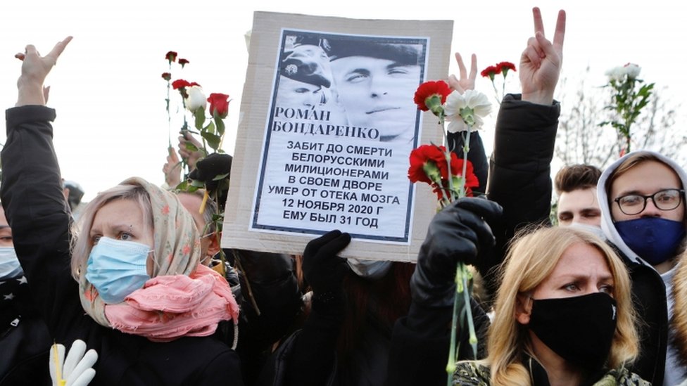 Люди держат портрет Романа Бондаренко, участника антиправительственного протеста, который скончался в больнице после жестокого избиения со стороны сил безопасности во время поминальной службы в его честь в Минске, Беларусь 20 ноября 2020 г.