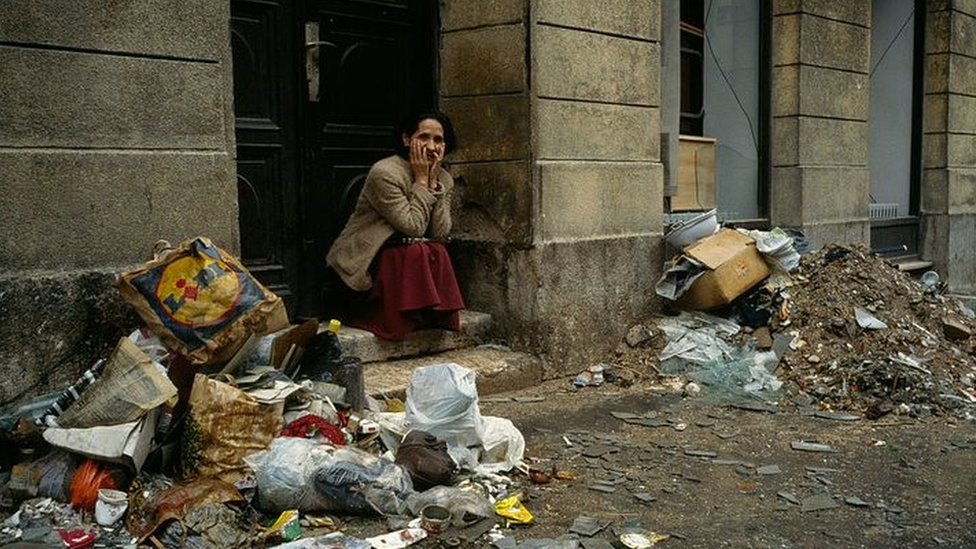 A woman sat among rubbish in Sarajevo